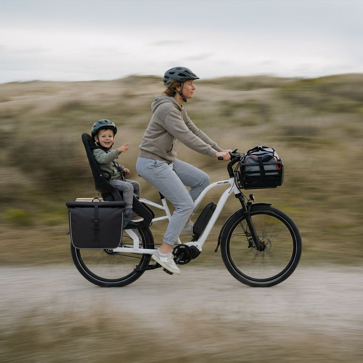Simply.Lift E-Lastenrad mit Gepäckträgertasche und Kind unterwegs