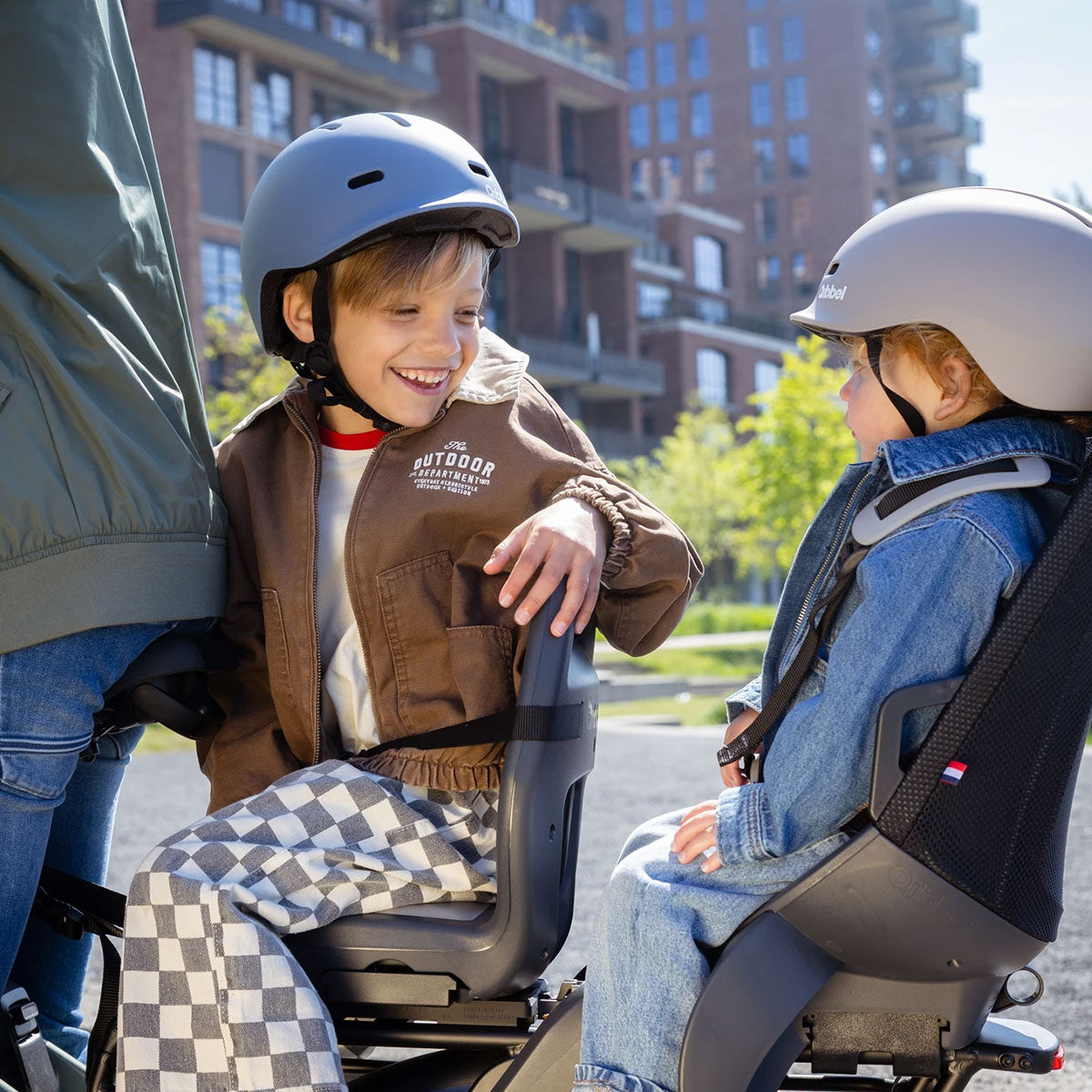 Zwei Kinder mit Helm in Qibbel Kindersitzen auf einem E-Lastenrad