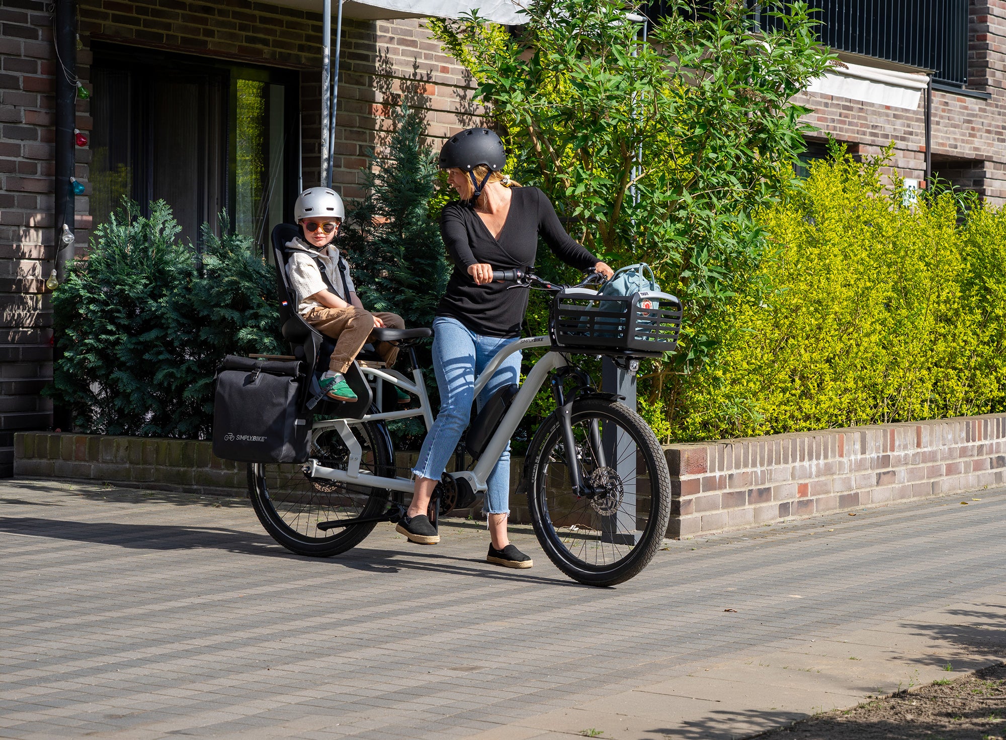 Simply.Lift EP6 Longtail E-Lastenrad mit Kind im Kindersitz auf dem hinteren Lastenträger.