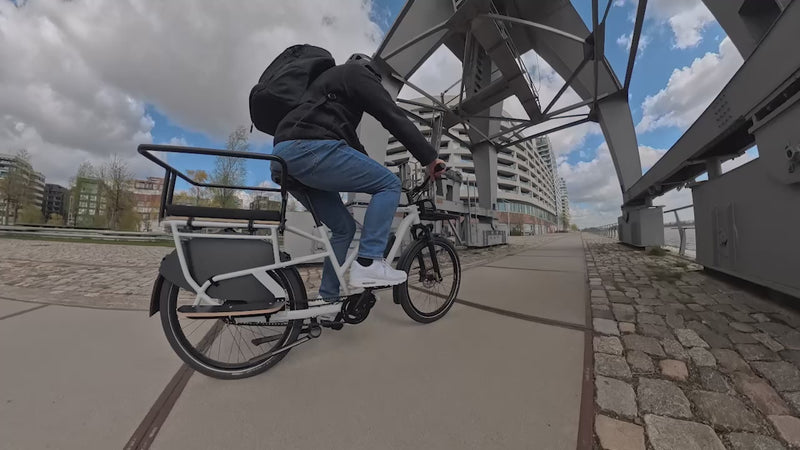Pendler fährt das Simply.Lift EP6 E-Lastenrad mit Shimano EP6 Mittelmotor durch die Stadt.