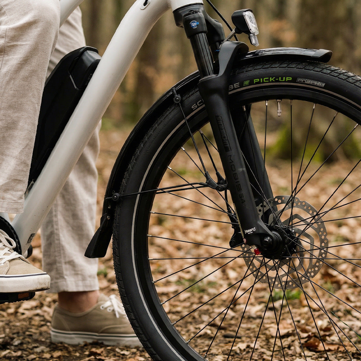 Nahaufnahme der Federgabel und des Vorderrads mit Scheibenbremse an einem Simply.Lift EP6 Longtail E-Lastenrad auf einem Waldweg.