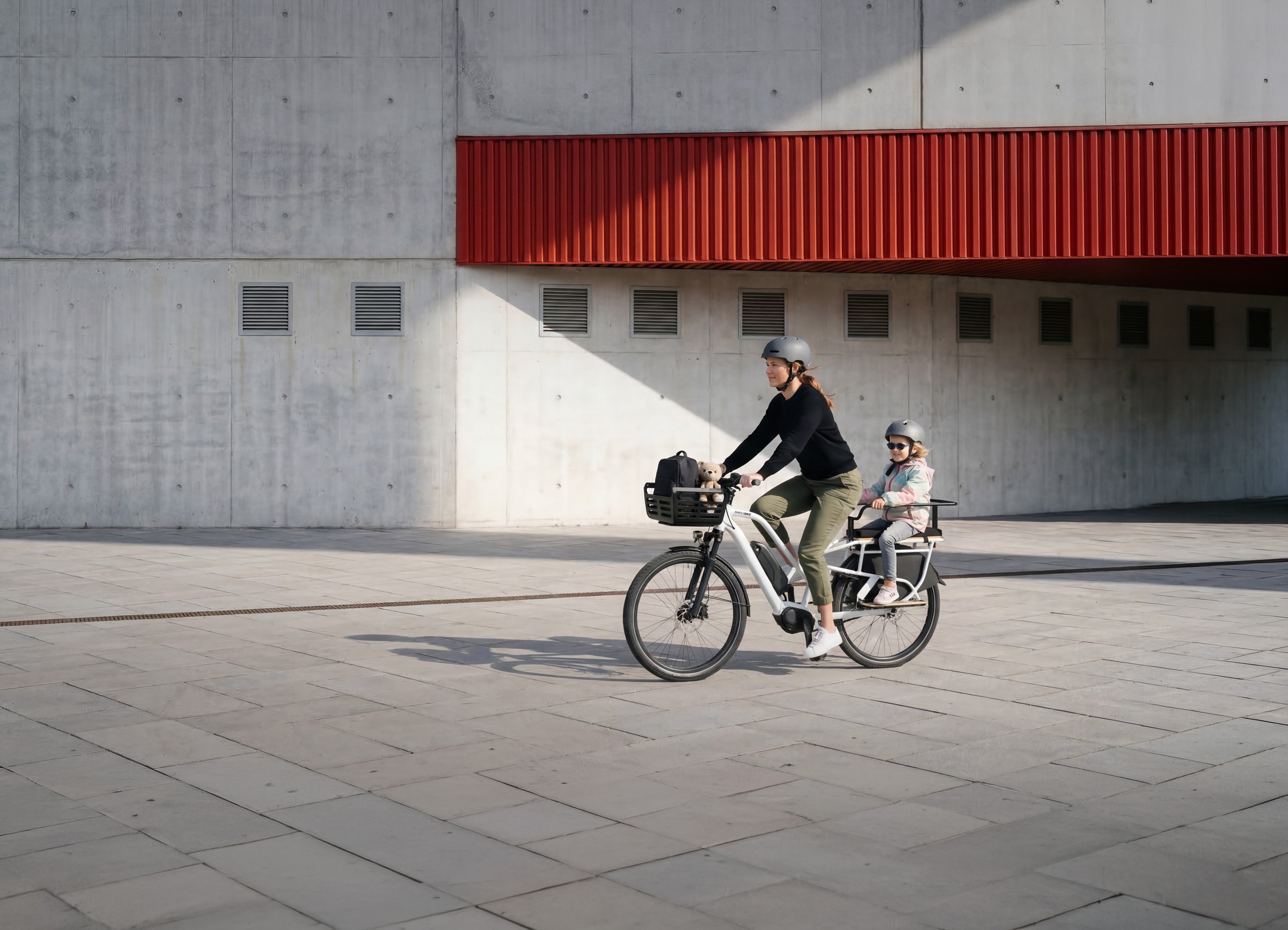 Simply.Lift EP6 Longtail E-Lastenrad mit einem Kind im Kinderhandlauf und Frontkorb.