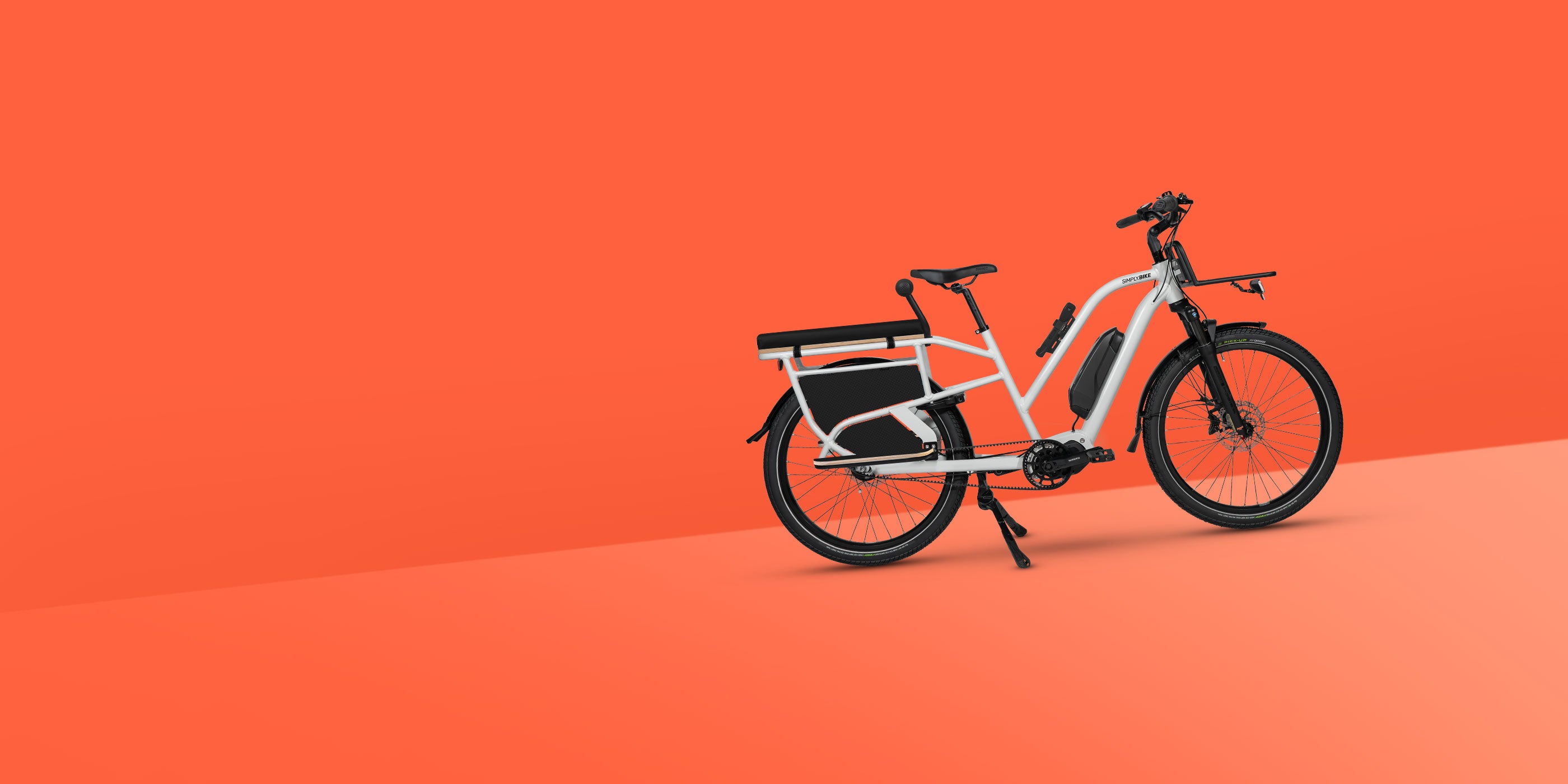 Simply.Lift Steps E-Cargobike für Familie mit Sitzpolster und Kindergriff auf dem Gepäckträger.