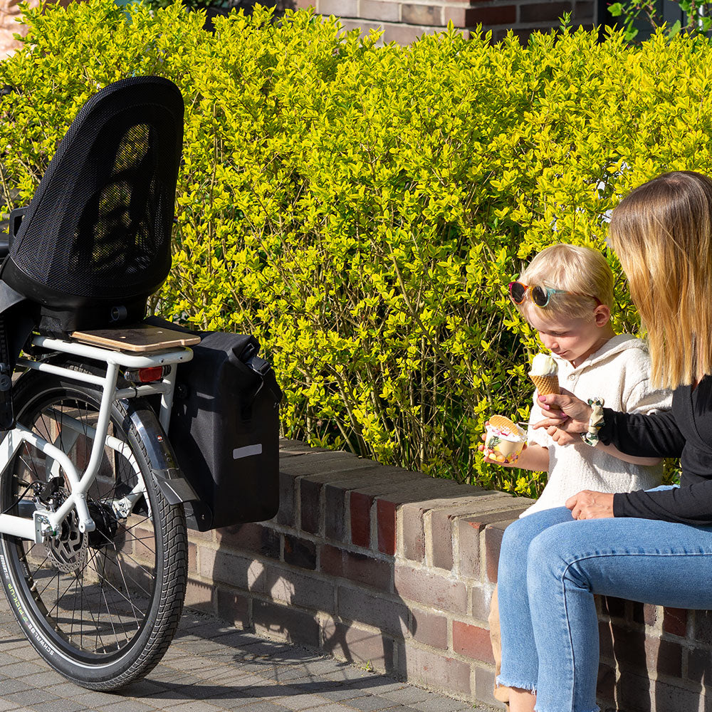 Vielseitiges Cargobike mit Gepäckträger und Seitentaschen im Einsatz.